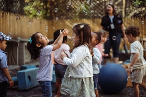 Corlears nursery students playing with bubbles in the backyard