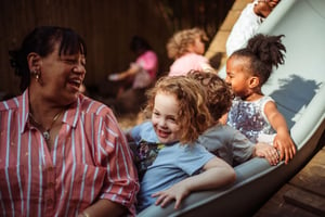 Betty having fun with students on the slide