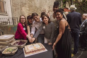 Group cutting the cake at Corlears 50th birthday party