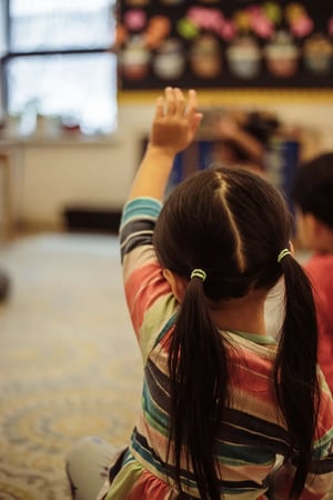 PreK student raising her hand