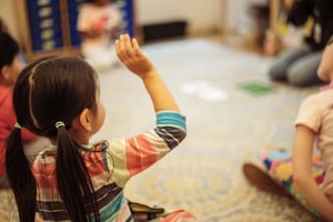 PreK student raising her hand