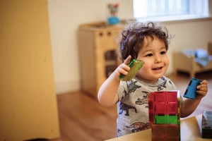 Roots student playing with magnatiles