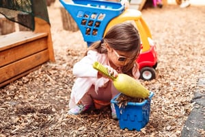 Seedlings student hard at work with a shovel and pail in the backyard
